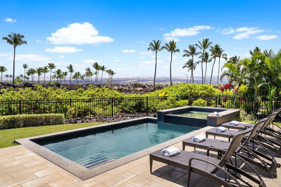 Relax by the private pool with golf course views and Mauna Kea in the distance.
