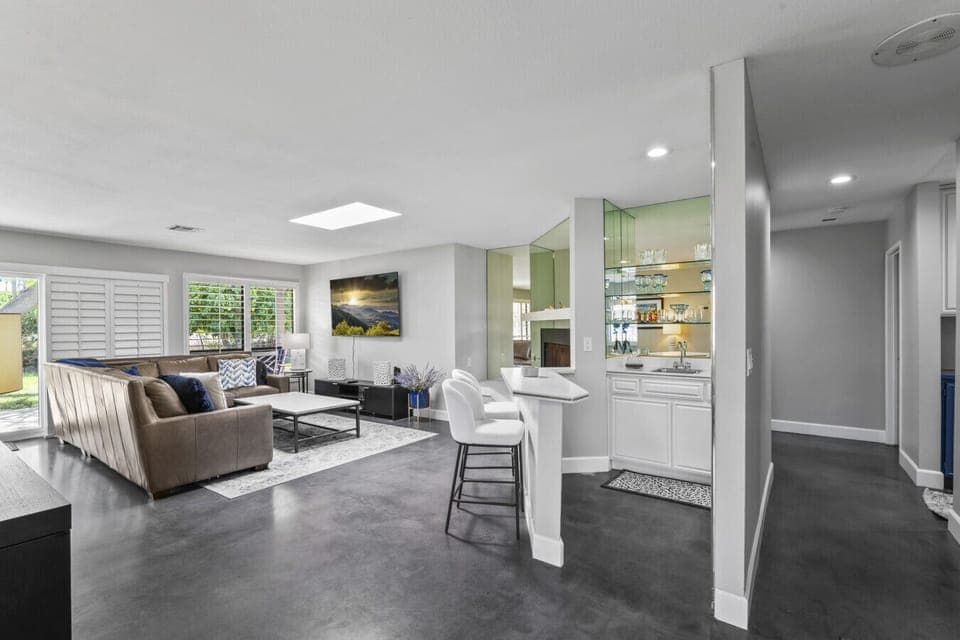 Bright, open living area with polished concrete floors, fireplace, and comfortable seating—perfect for relaxing, game nights, or movie time.