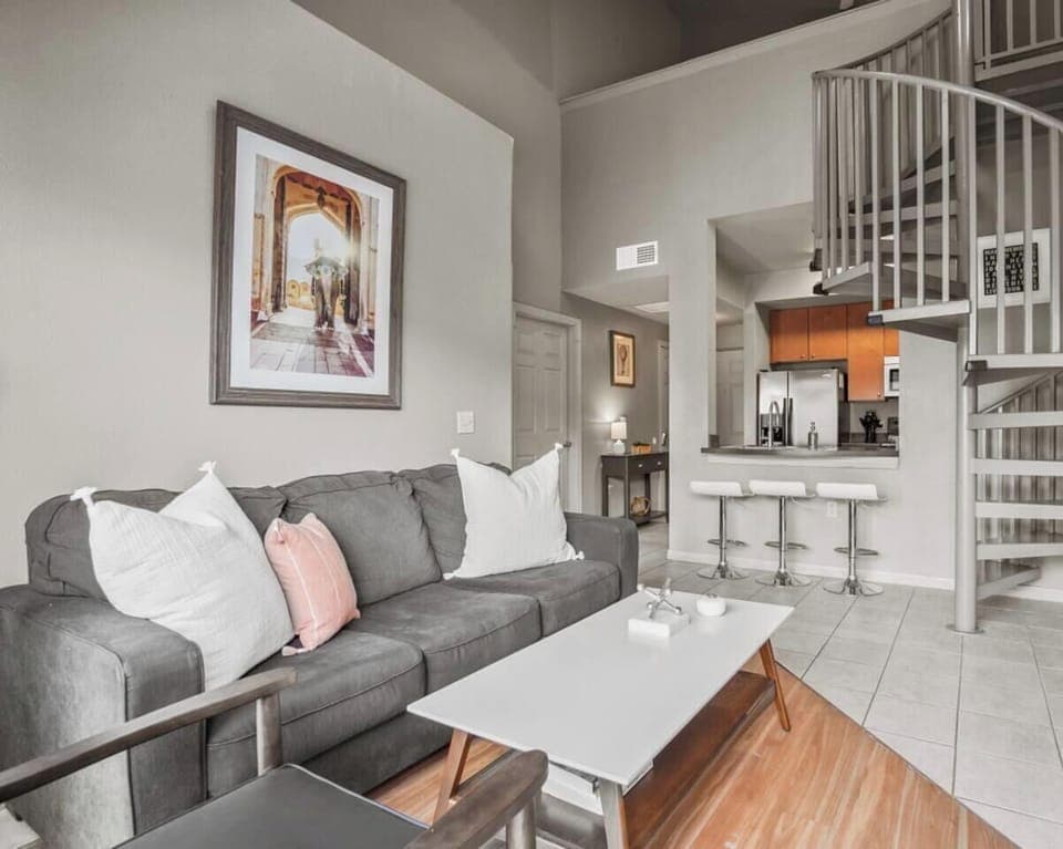 Living room in the second apartment with sleeper sofa and spiral staircase