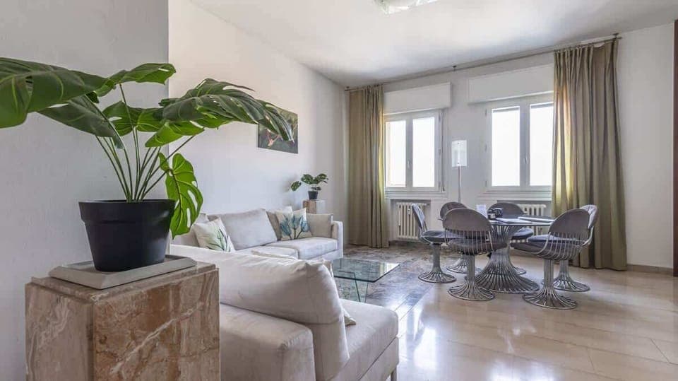 luminoso ed ampio soggiorno con divano e tavolo da pranzo