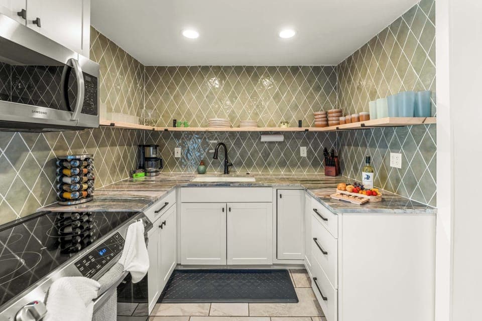 Fully stocked kitchen, with drip coffee maker (complimentary ground coffee, sugar and tea), cookware, dinnerware, and spices. Guests supply their own condiments.