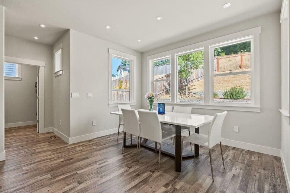 Chic dining area with floor-to-ceiling windows and serene hillside views — a bright space to share meals and conversation.