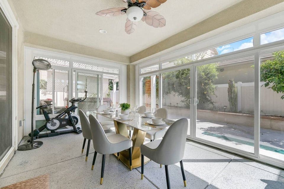 Stylish dining area featuring glass walls and direct access to the patio — perfect for family dinners.