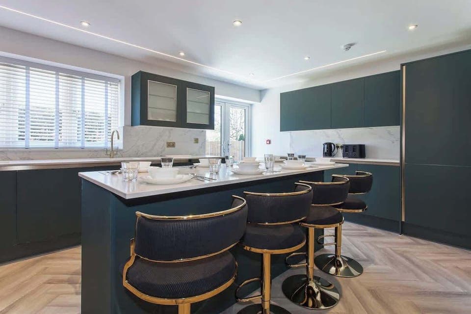 Stylish open-plan kitchen and dining area with breakfast bar seating, perfect for meals and socializing