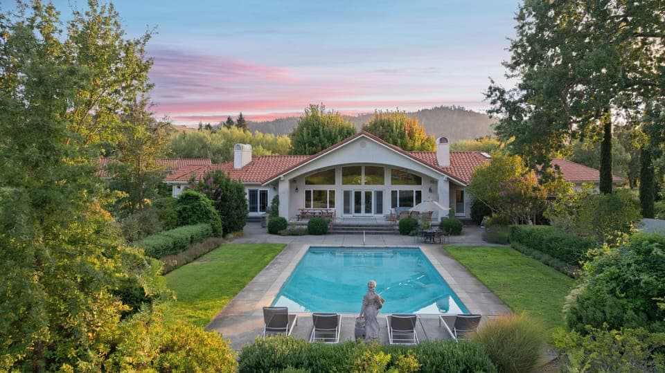Stunning curb appeal with a beautifully landscaped front yard and sparkling pool.
