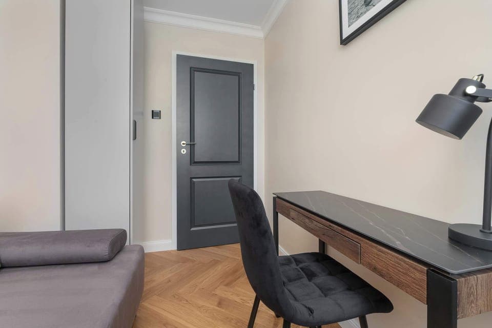 The bedroom featuring a functional workspace with a desk and chair.