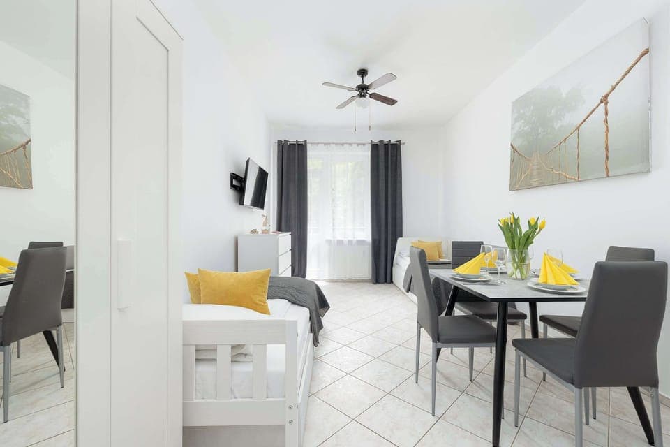 Beautifully arranged lounge area with a soft grey single beds, decorative cushions, and warm yellow accents creating a homely atmosphere.