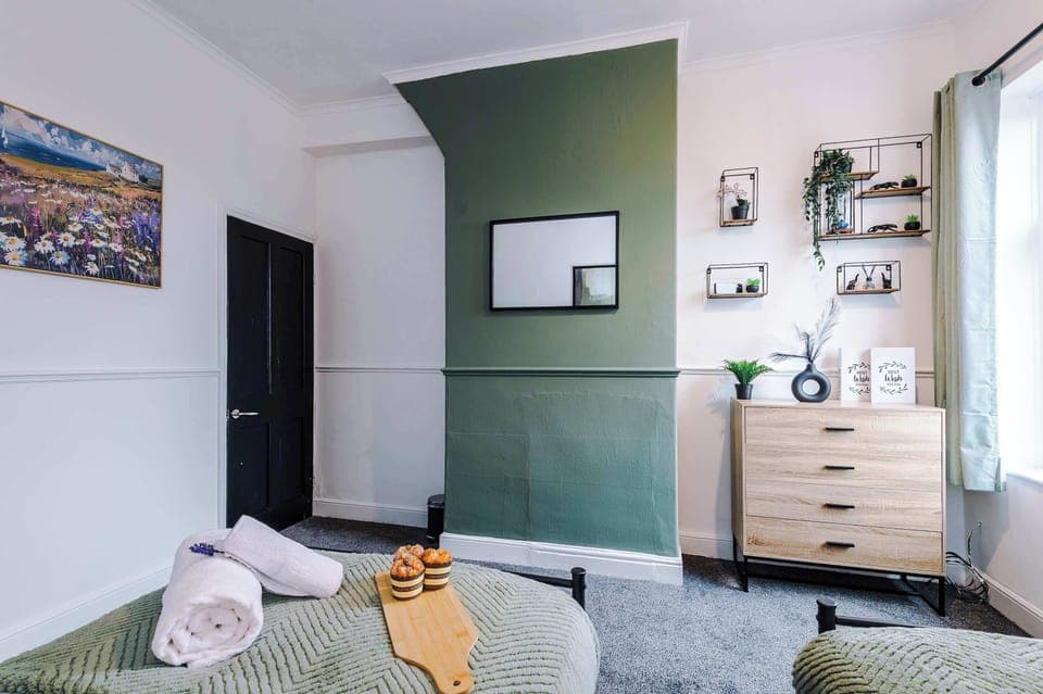 Bedroom 2 features 2 x single beds, perfect for friends or workers. This bedroom has a built in wardrobe, chest of drawers and lovely green decor.