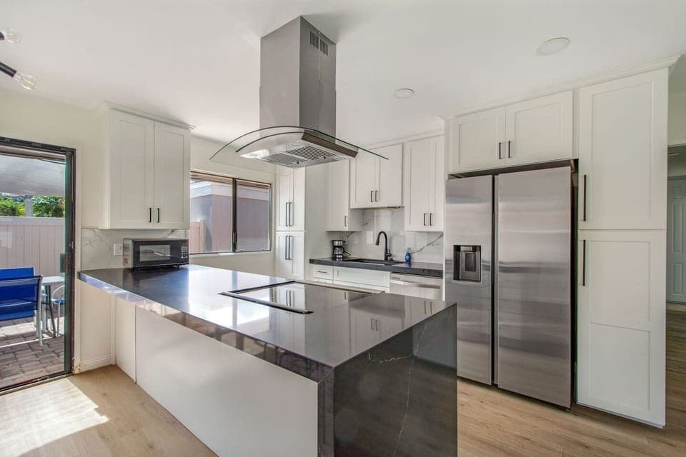 Modern kitchen with sleek countertops and stainless steel appliances.