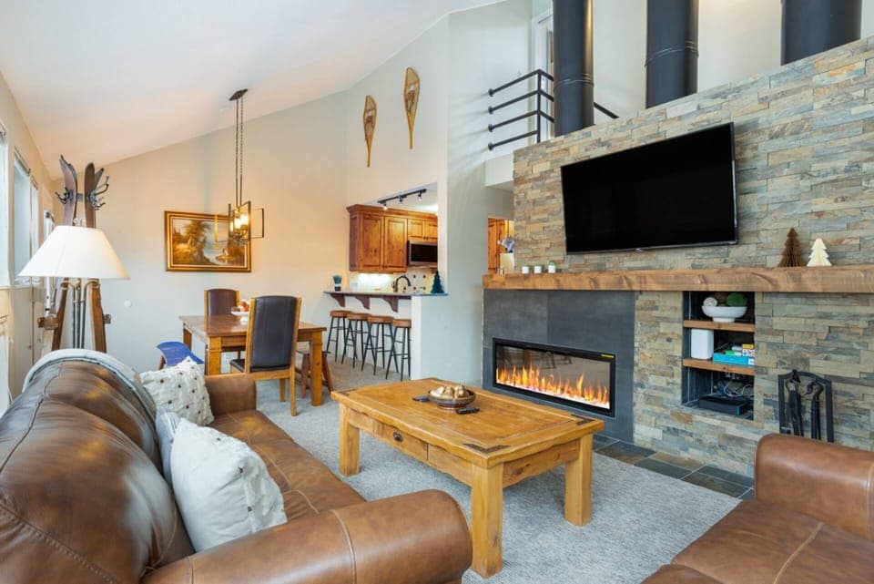 A bright, welcoming gathering space with mountain charm and a modern fireplace centerpiece.