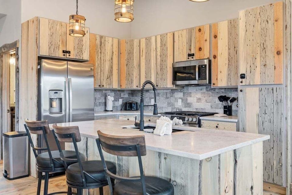 Your rustic dream kitchen at 128 GCR 4034 awaits with reclaimed wood cabinets, modern appliances, and a welcoming island perfect for morning coffee and evening conversations.