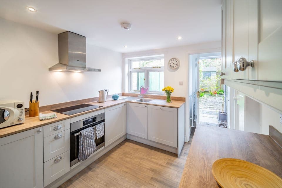 Dragonfly Cottage, Holt: Well-quipped kitchen with an integrated washing machine, fridge with icebox, electric oven and induction hob, microwave and door to the garden