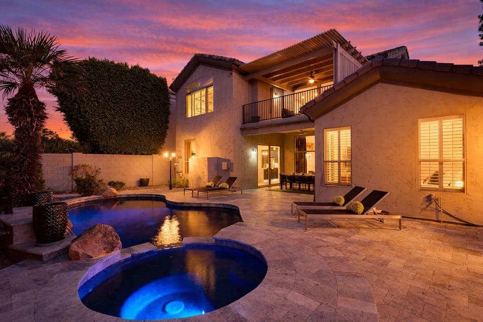 Backyard oasis featuring a covered patio w/ dining, sparkling pool with spa, plus a built-in grill and fireplace perfect for outdoor gatherings.
