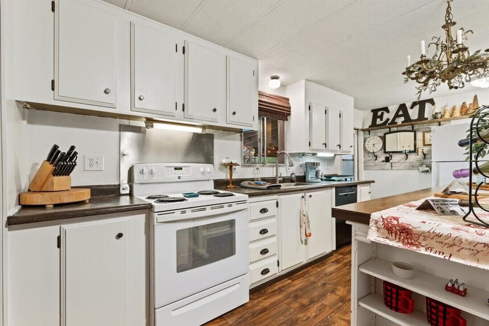 Light and bright kitchen with electric stove and dishwasher