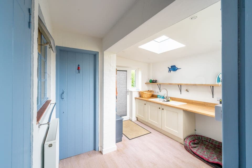 Ground floor: Utility room with a dog bed, WC and entrance to front garden