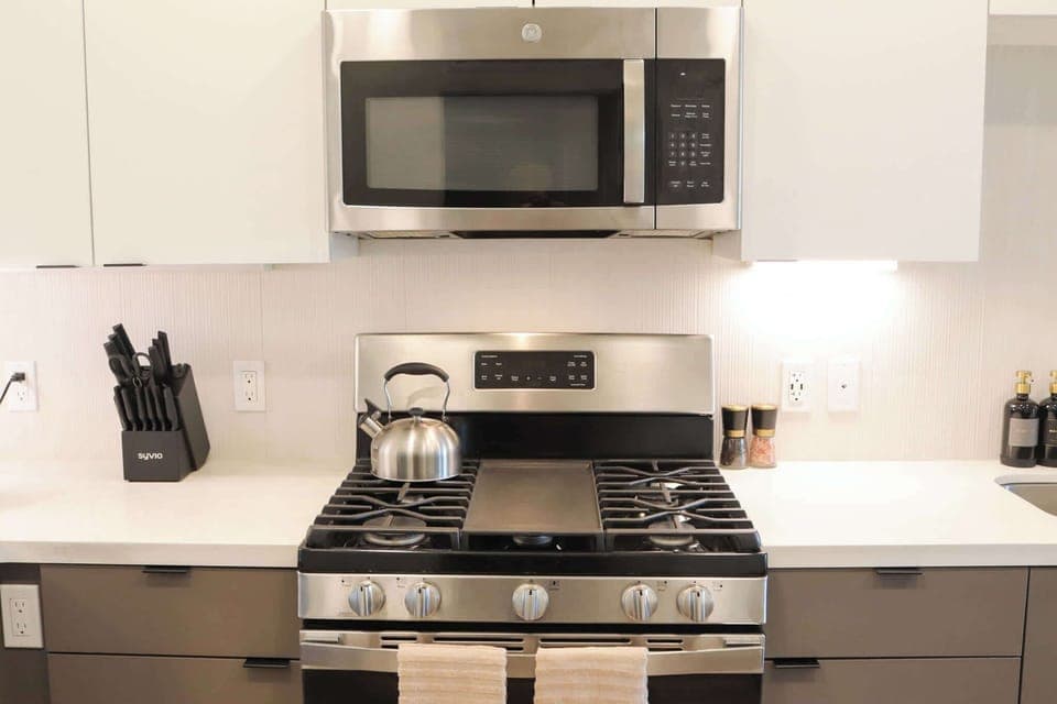 Experience extended comfort with a fully equipped kitchen featuring a coffee machine, stovetop, and microwave—everything you need for a seamless long-term stay