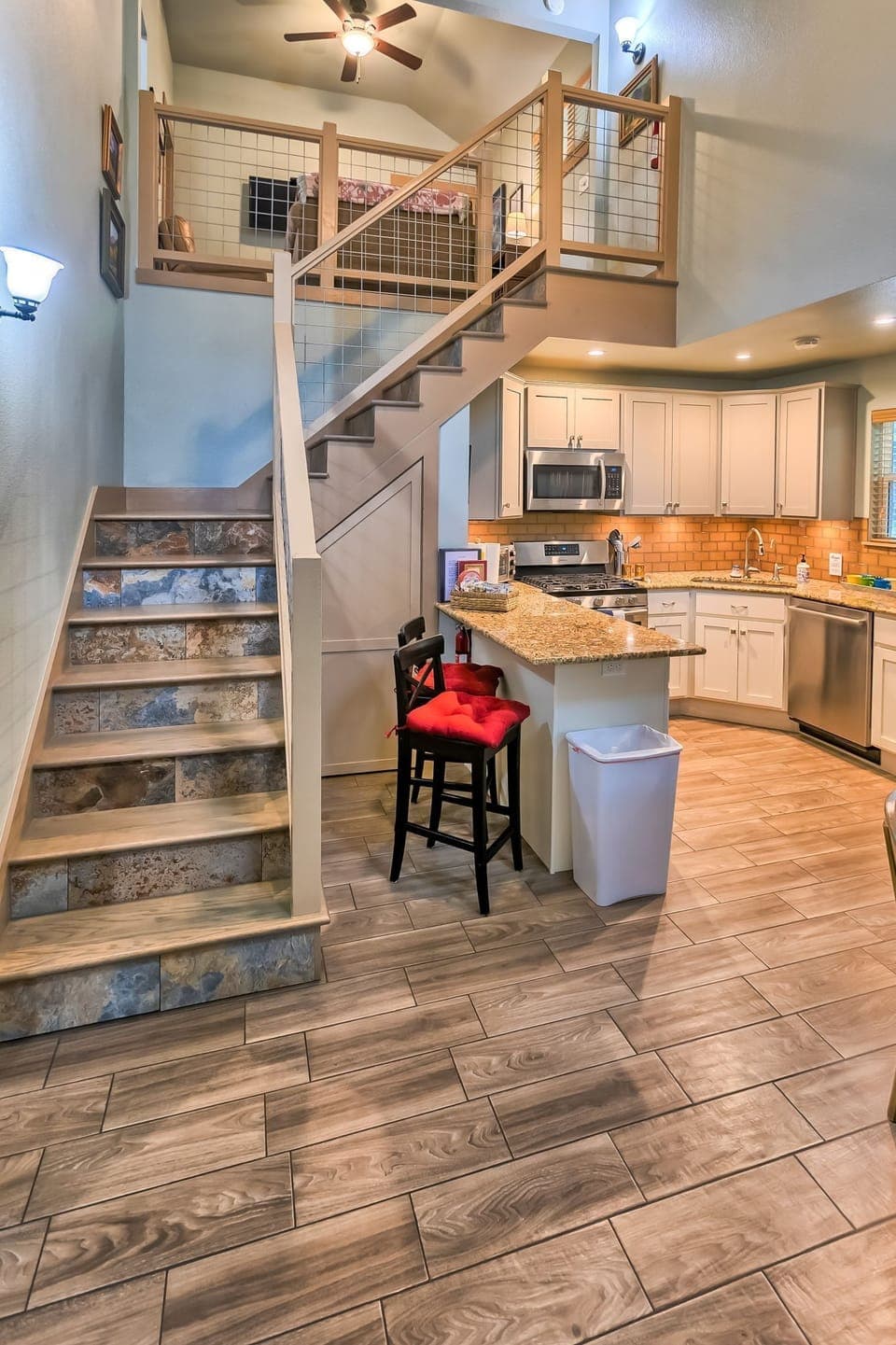Kitchen island & stairs to loft. A child gate is at the top of the stairs.