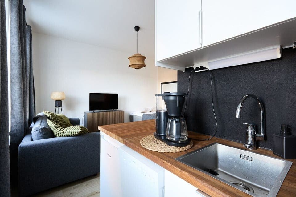 Prepare your favorite meals in the fully equipped modern kitchen featuring all necessary appliances and cookware. Start your mornings right with a fresh cup of coffee at the stylish breakfast bar.