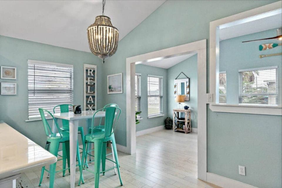 A breakfast nook has teal barstools and lots of natural light