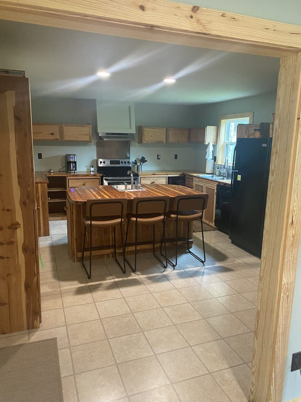 Large kitchen with island and bar with stools