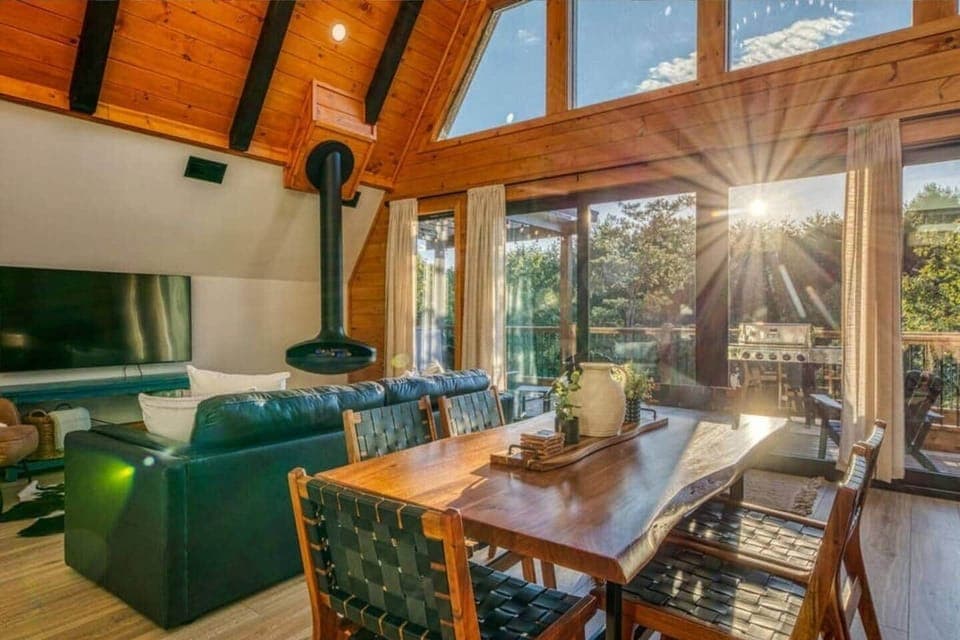 Gather around the stylish dining area that comfortably seats your group. Enjoy delicious meals in a space that feels both intimate and connected to the natural surroundings, thanks to panoramic windows and open design.