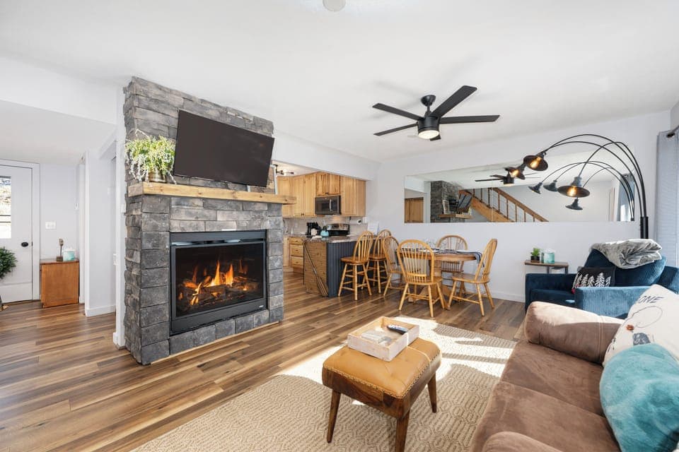 Cozy up by your stone fireplace while enjoying this open living space at Soda Springs Ranch condo 3C with modern kitchen and comfortable seating.