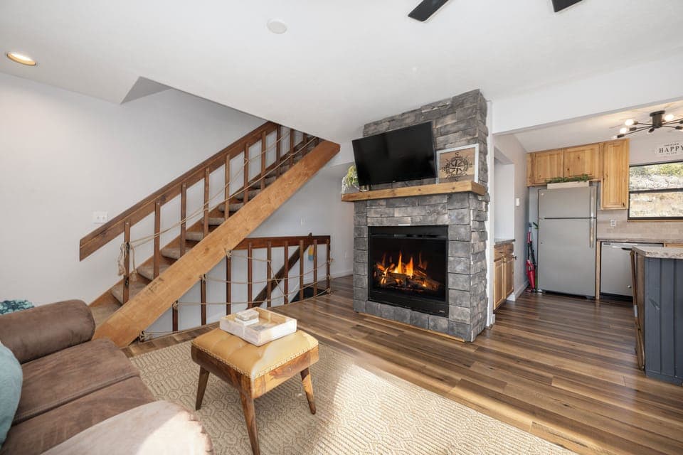 Cozy up by your crackling stone fireplace while watching TV in this warm living space with rustic wood accents at our Soda Springs Ranch condo 3C..
