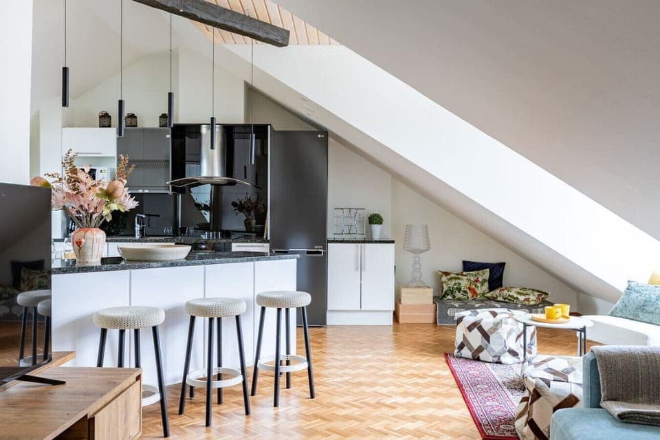 Modern kitchen featuring a large island with stylish bar stools — a welcoming space for relaxed breakfasts or evening drinks.