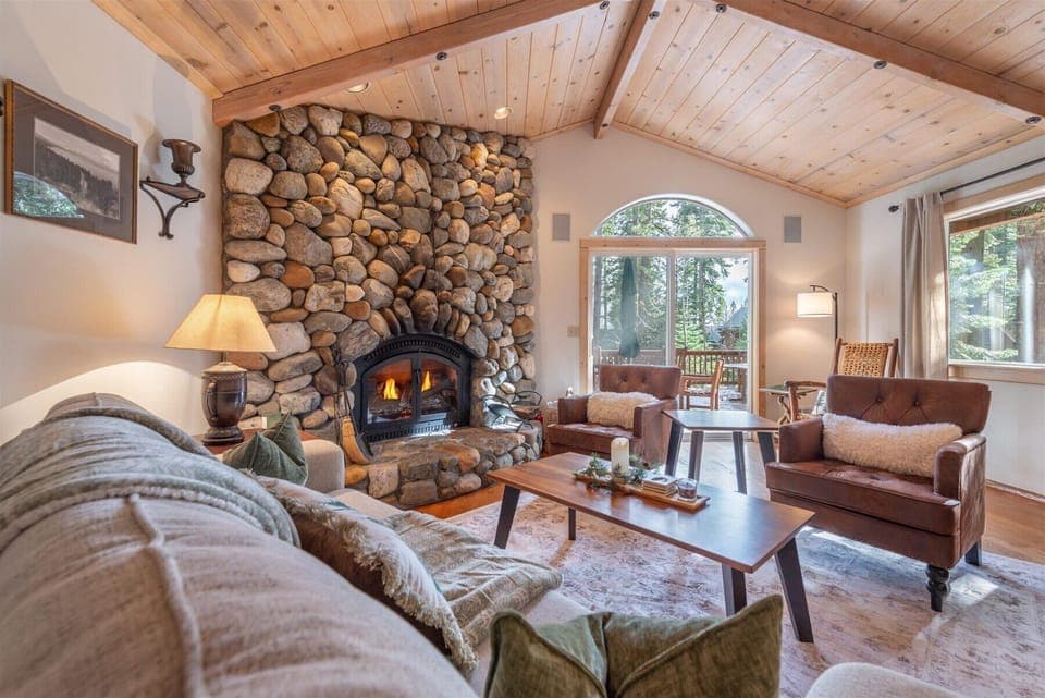 Curl up in this cozy living room, where vaulted wood ceilings and forest views create the perfect mountain retreat for unwinding after your adventures.