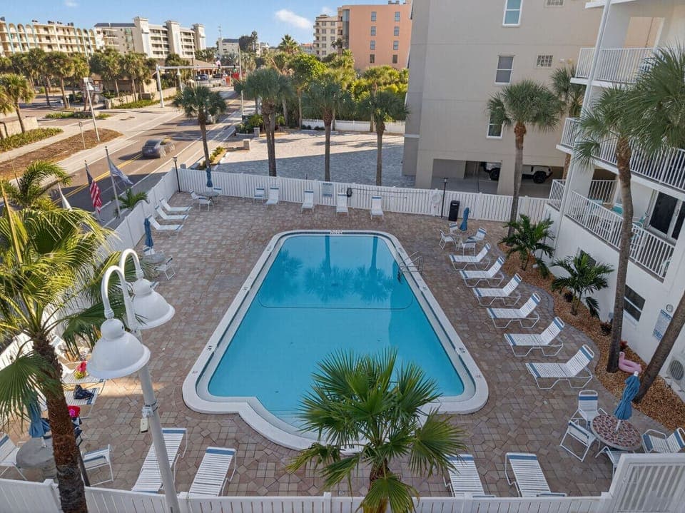 Sparkling resort-style pool surrounded by loungers, perfect for cooling off or soaking up the sun.