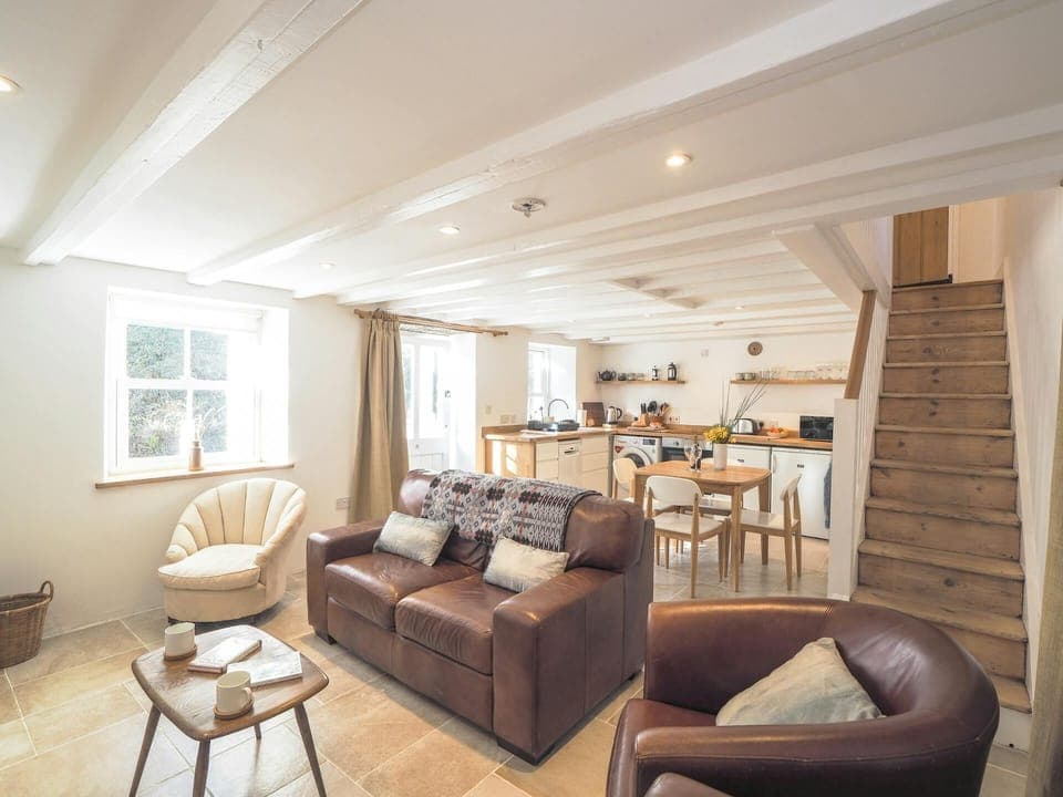 Coffee table, sofas, view into kitchen and up the stairs