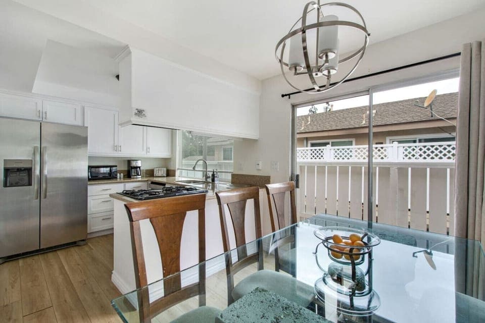 Modern dining area with table seating for six, connected to a fully equipped kitchen for easy meals.