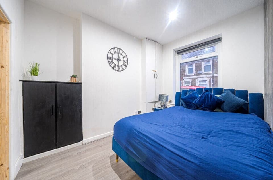 Bright bedroom with blue upholstered bed