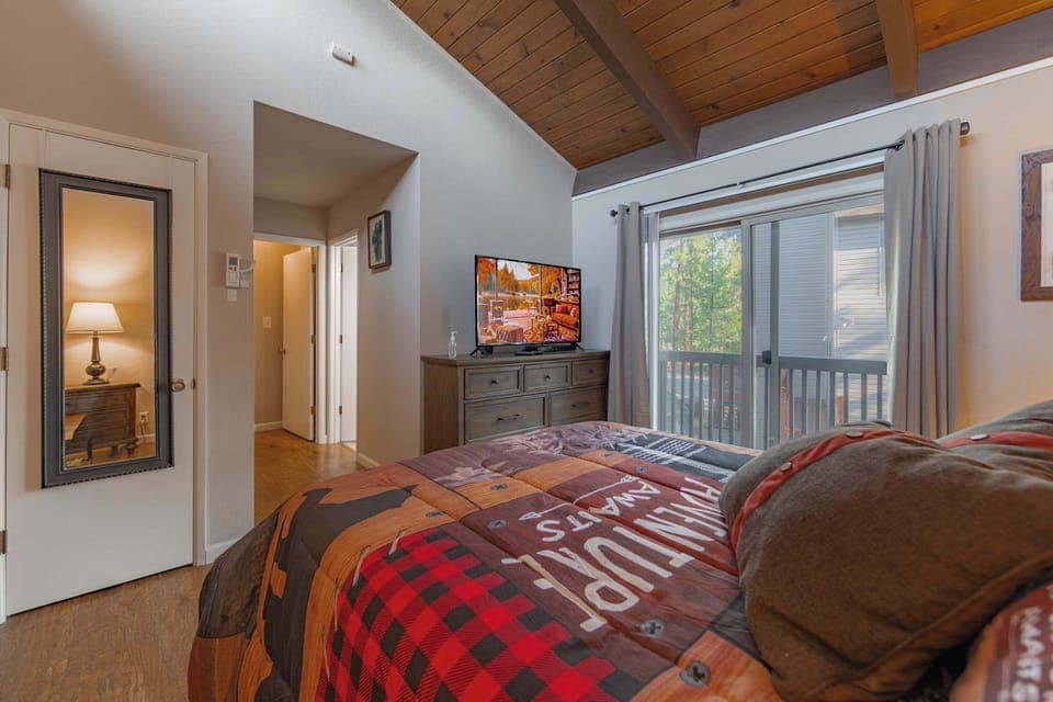 Bedroom 2 with queen bed, balcony, Smart TV, and ensuite