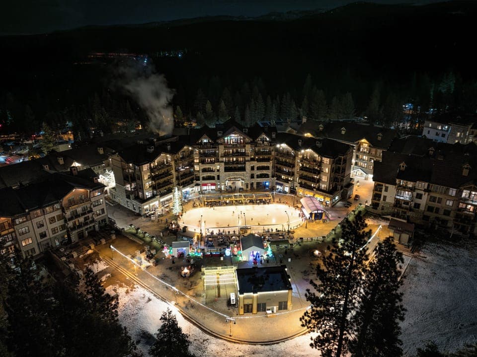 The resort glows under a blanket of stars, creating a magical nighttime atmosphere perfect for après-ski relaxation.