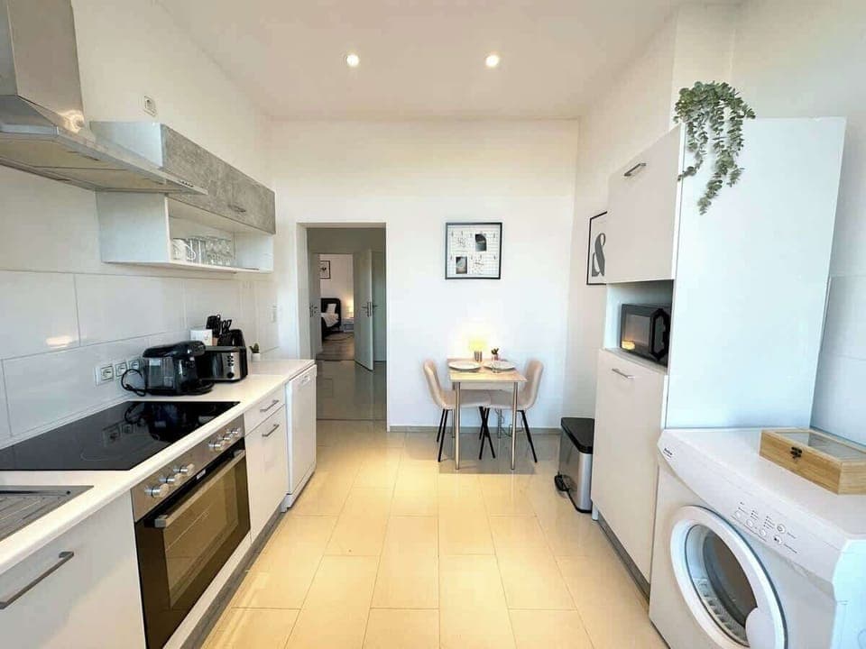 Die geräumige, helle Küche lädt zum gemeinsamen Kochen ein. Mit modernen Geräten, einem Esstisch und viel Arbeitsfläche ist sie ideal für Familien oder Gruppen. 