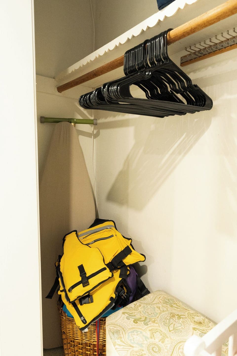 Closet stocked with life jackets, hangers, and ironing essentials.