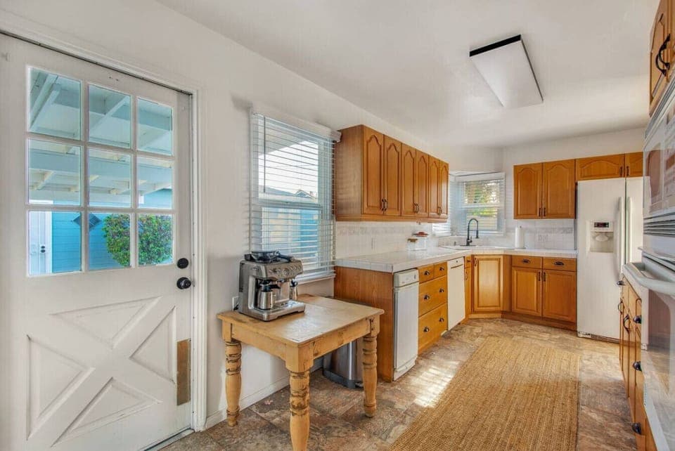 Fully equipped kitchen with ample counter space and direct access to the backyard.