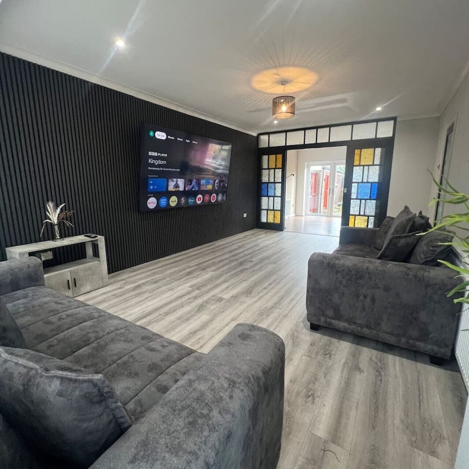 Spacious lounge with 100-inch cinema screen and modern decor