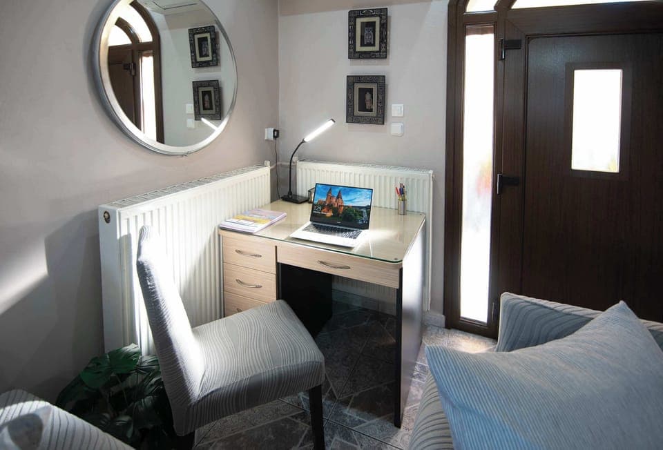 Quiet work corner with a comfortable chair and natural lighting, ideal for reading, writing, or remote work whenever needed.