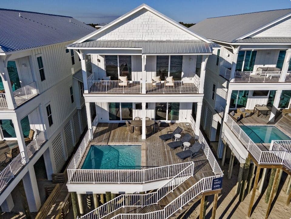 Beach side of house, large pool deck and upstairs balcony
