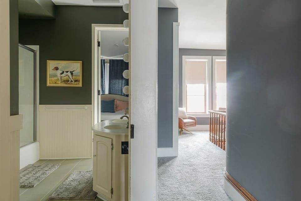 Vintage dog portraits and globe lighting continue boutique design into bathroom.