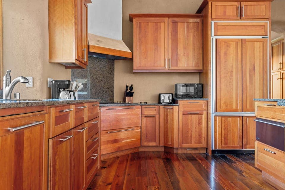 A culinary playground where artisan craftsmanship meets high-end functionality, featuring warm wood cabinetry and soft, organic lines.