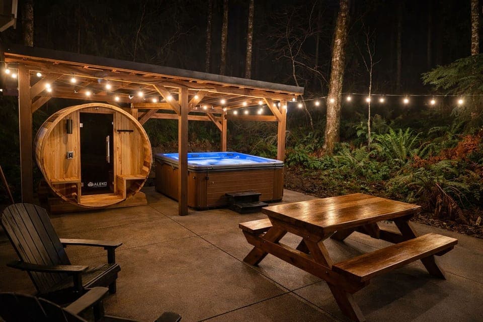 Private cedar hot tub under café lights in a quiet forest setting
