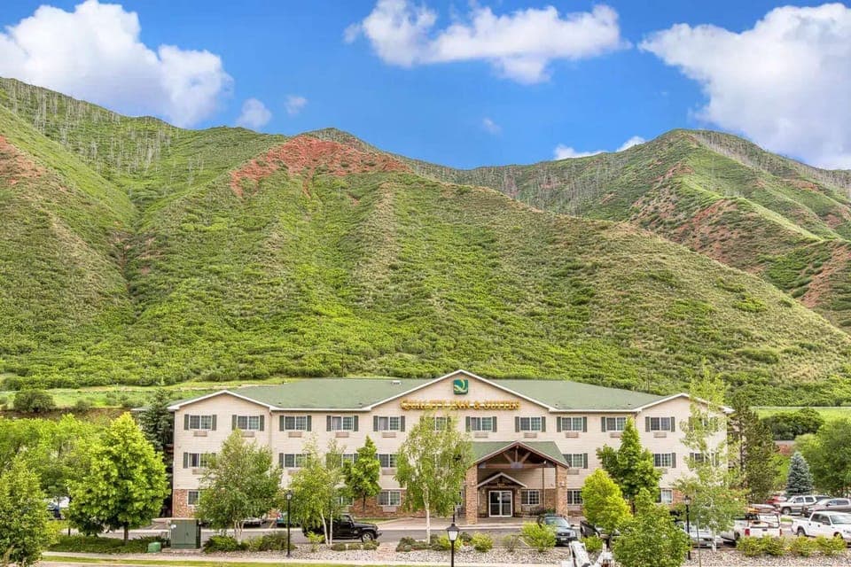 Full front view with mountain backdrop and tree-lined path
