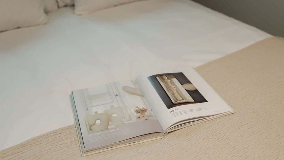 A moment of calm — soft bedding, reading material and a neutral palette to help you slow down.