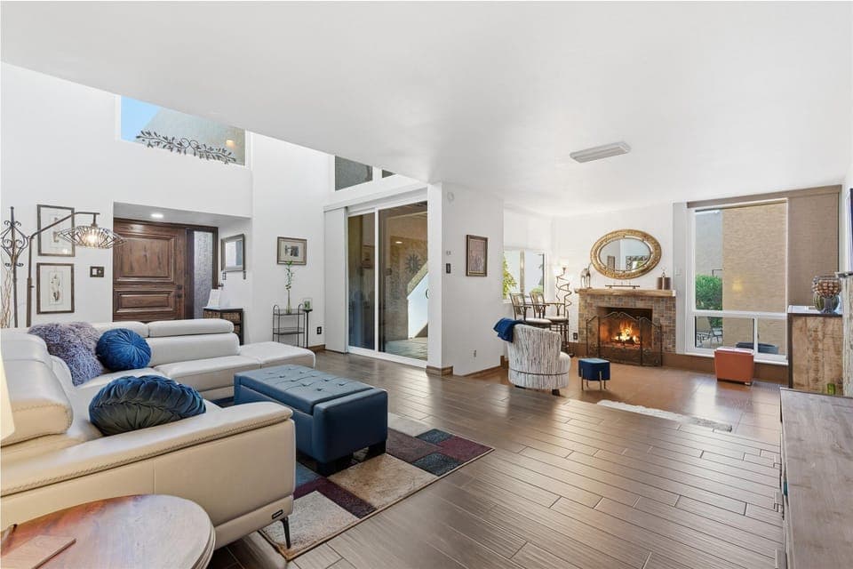 Main living area featuring cozy furnishings, a smart TV, fire place, and access to the 1st patio.