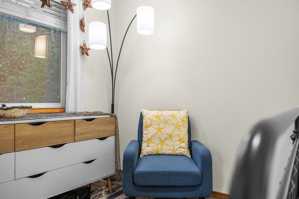 Corner of a bedroom with a blue accent chair.