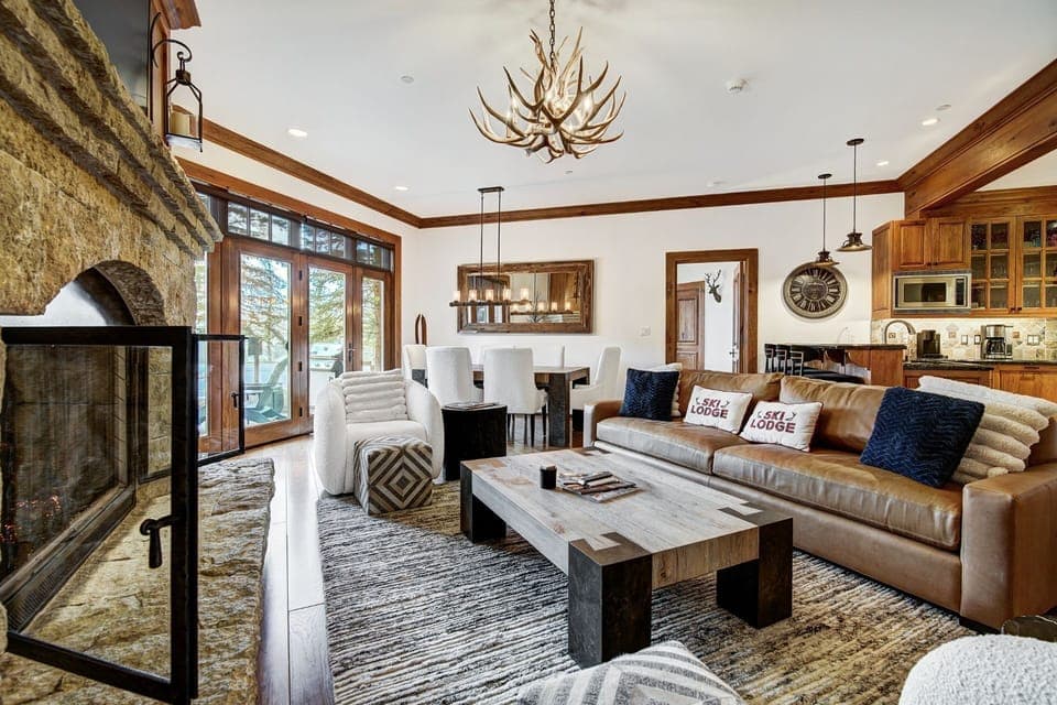 This elegantly appointed living space features a cozy blend of rustic stonework and modern comforts, complemented by stunning views of the surrounding alpine scenery.