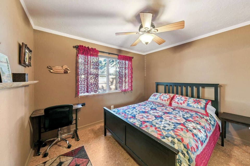Cozy, sunlit bedroom with a comfy bed, ceiling fan, and workspace—perfect for restful nights and relaxed mornings during your stay.
